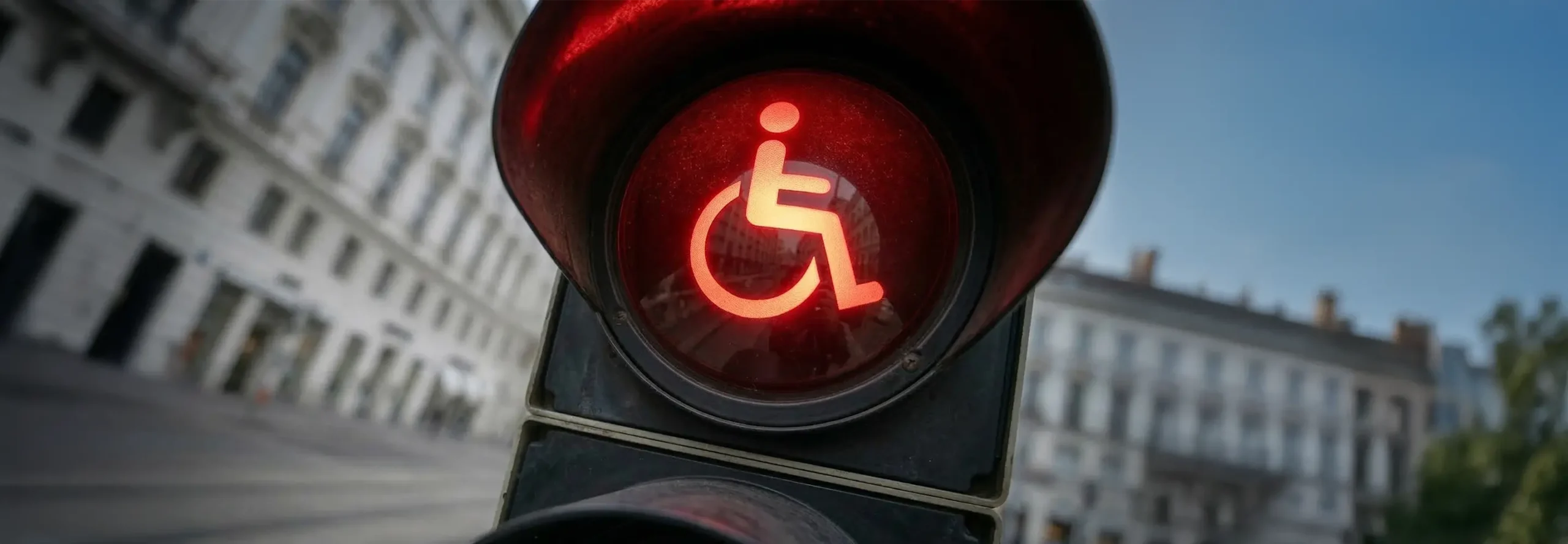 Rotes Ampelsymbol für Menschen im Rollstuhl vor städtischen Gebäuden
