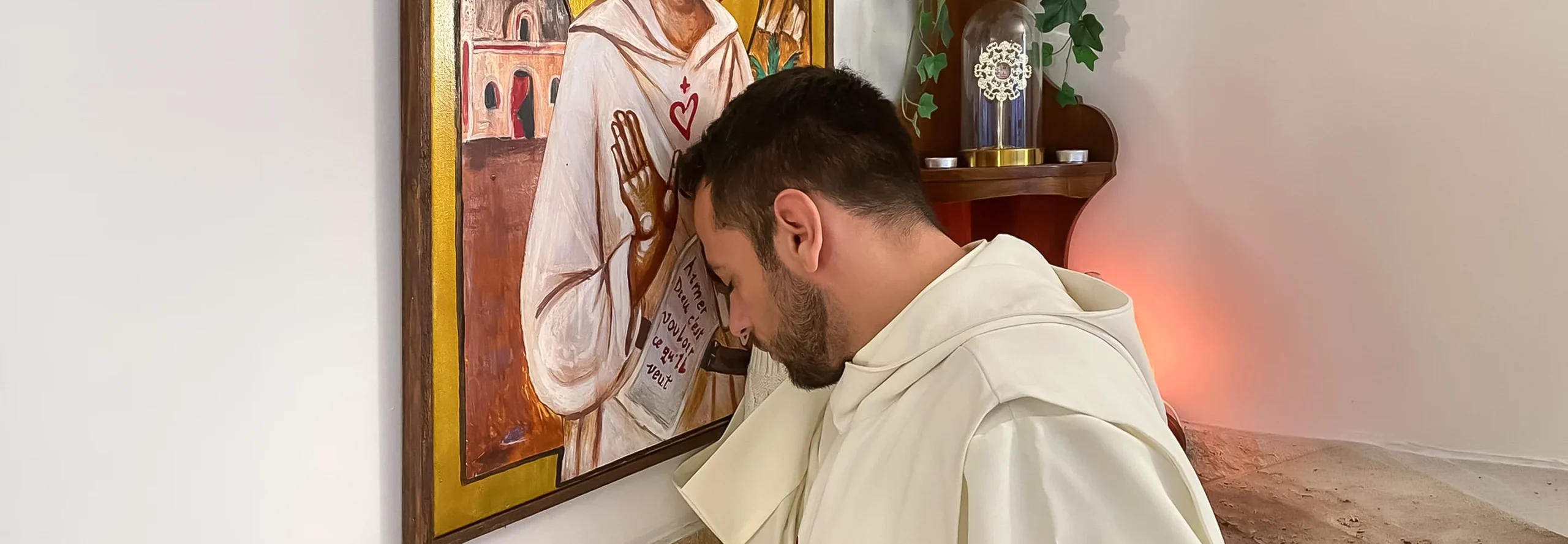 Mann in weißer Kleidung betrachtet ein religiöses Bild