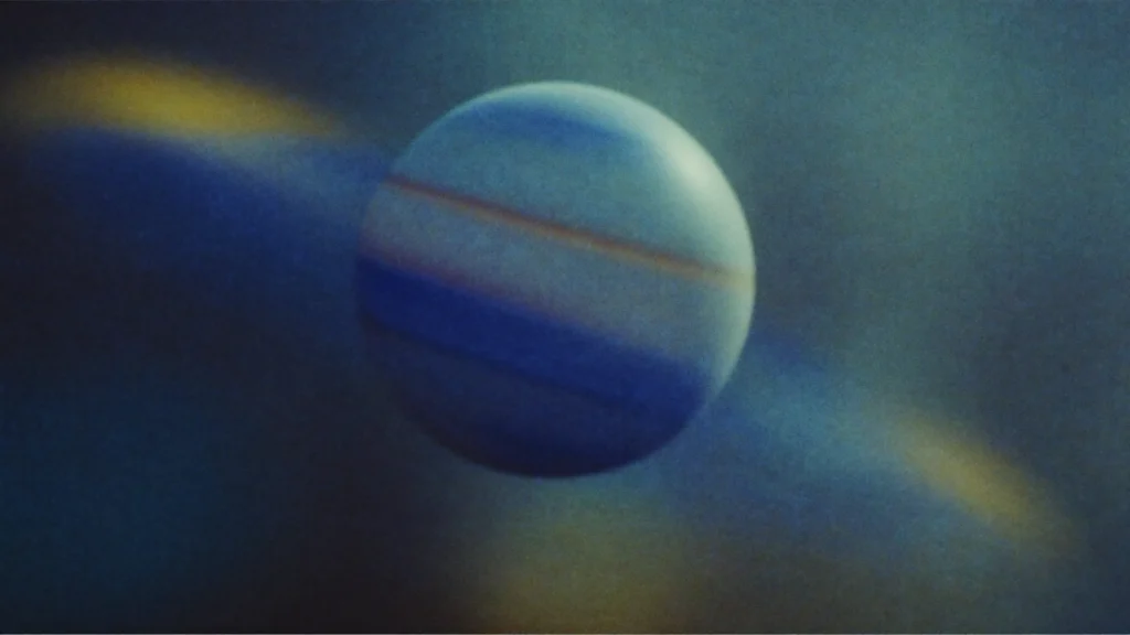 Cinematic shot of Saturn with its rings, drifting slightly backward in a dark starfield, sense of weight and structure, deep indigo palette with muted gold light (hex 948f74), editorial, minimal, no text.