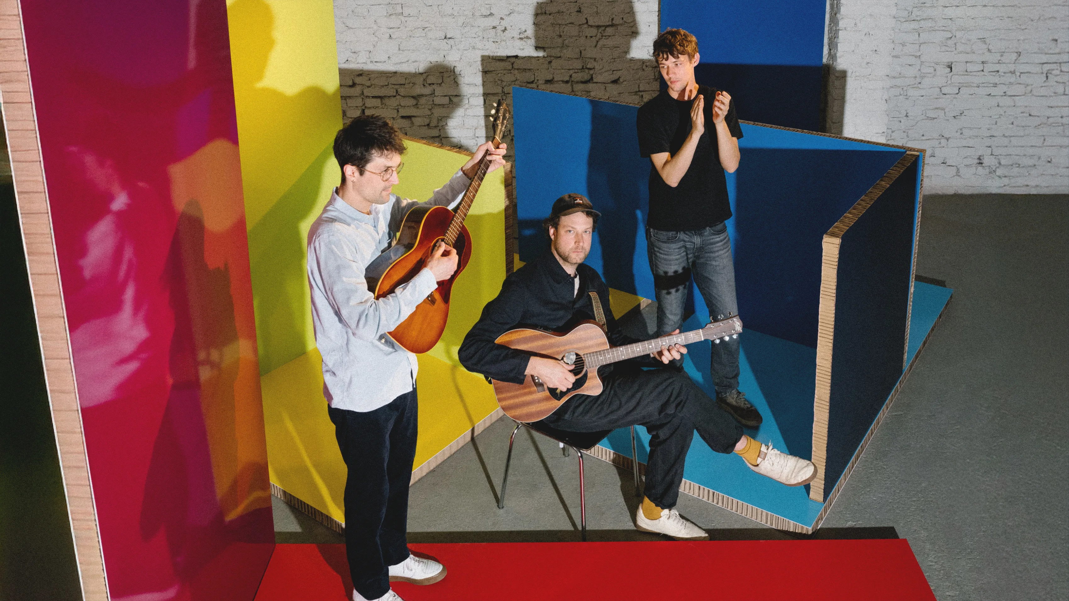 Henning May répète avec Christopher Annen et Severin Kantereit dans un espace musical moderne à Vienne.