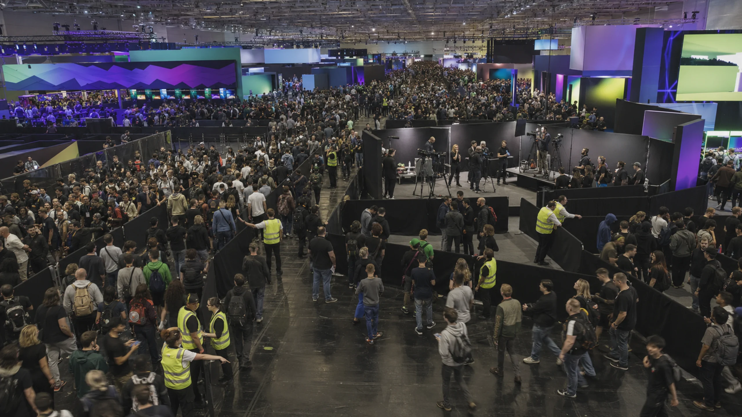 Une grande salle de la gamescom montre le public des jeux vidéo et les flux de visiteurs organisés autour des espaces créateurs.