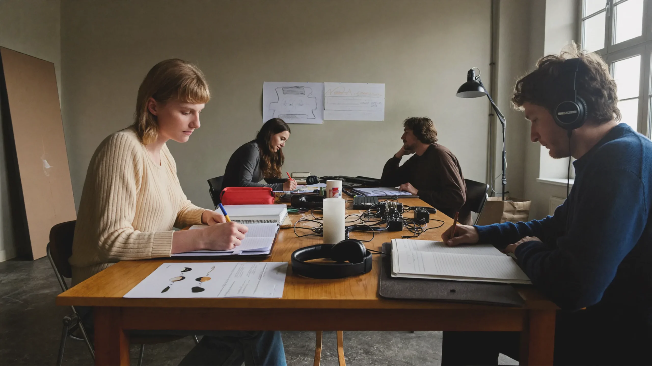 Menschen nutzen in einem ruhigen Wiener Arbeitsraum unterschiedliche Werkzeuge und Arbeitsweisen.