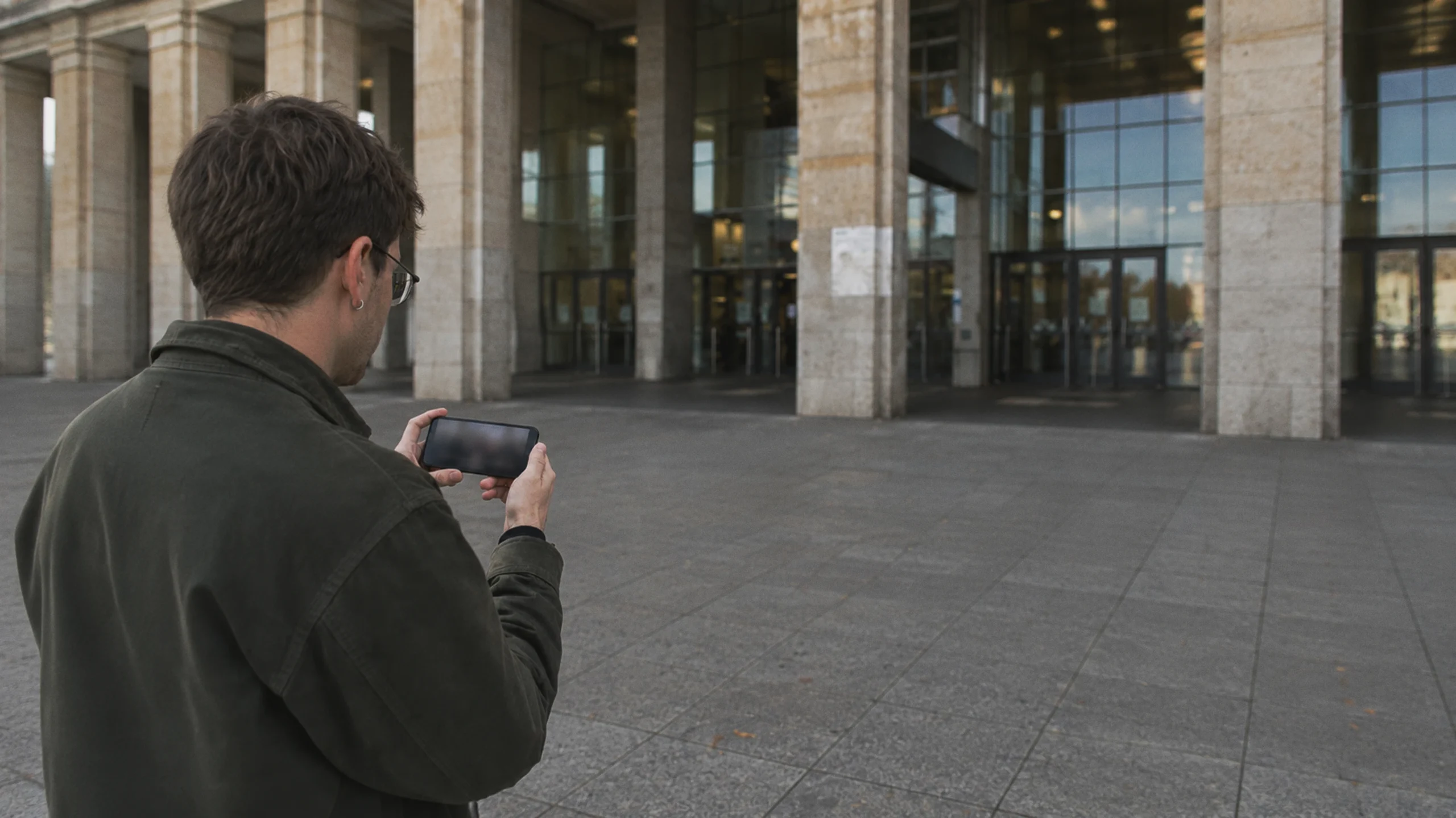 Un éditeur examine l'affaire Ski Aggu et Jens Spahn devant le site de Tempelhof à Berlin, sur un smartphone.