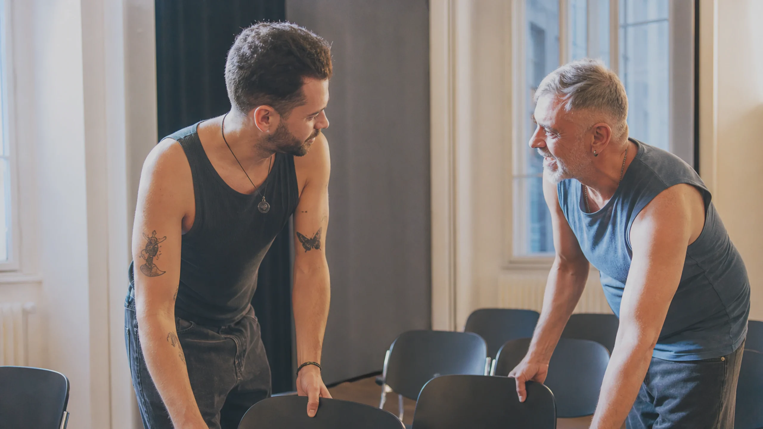 Un homme gay plus jeune et un homme gay plus âgé préparent ensemble une pièce pour des conversations