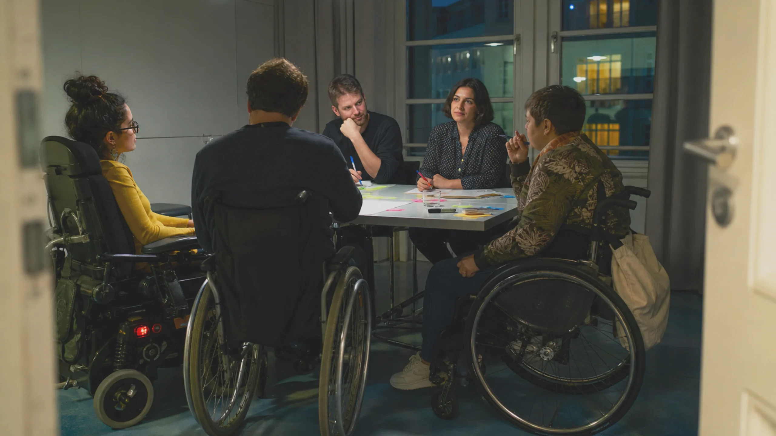 Des adultes handicapés participent à une discussion avec des membres du personnel concernant la conception des services.