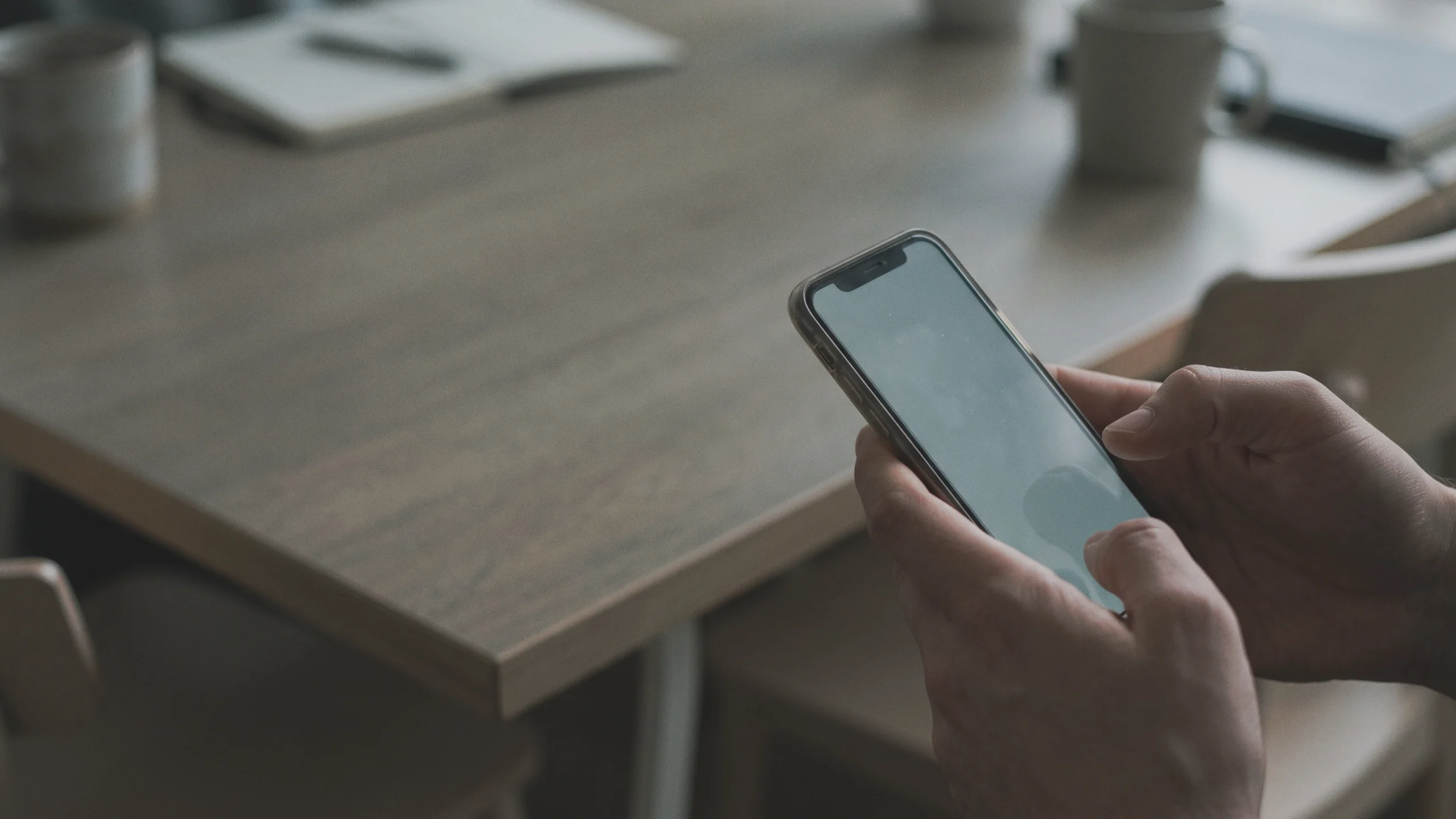 Des mains tiennent un smartphone lors d'une discussion publique en ligne sur la jalousie.
